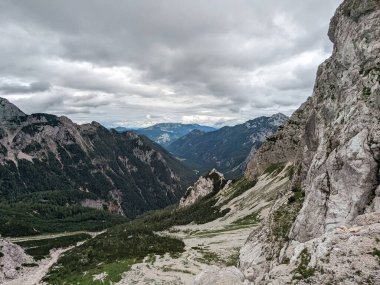 Sloven Alplerinin tepelerinin bulutlarla kaplı olduğu Logarska Dolina Vadisi 'nin panoramik manzarası.