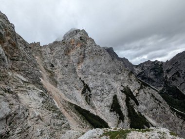 Sloven Alplerinin tepelerinin bulutlarla kaplı olduğu Logarska Dolina Vadisi 'nin panoramik manzarası.