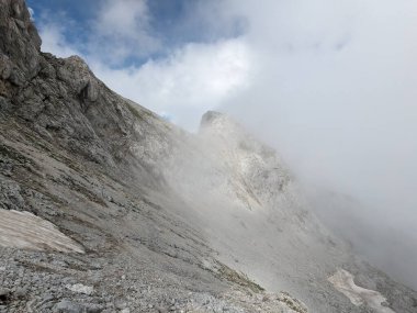 Sloven Alplerinin tepelerinin bulutlarla kaplı olduğu Logarska Dolina Vadisi 'nin panoramik manzarası.