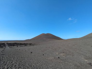 Lanzarote, Kanarya Adaları 'ndaki volkanik dağ manzarası dramatik arazileri ve kurak doğal güzellikleri gösteriyor.