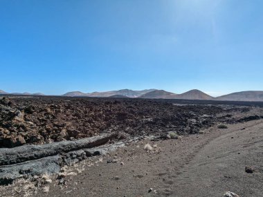 Lanzarote, Kanarya Adaları 'ndaki volkanik dağ manzarası dramatik arazileri ve kurak doğal güzellikleri gösteriyor.