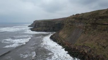 İngiliz-İskoç kıyı şeridi boyunca uzanan engebeli uçurumların dramatik hava manzarası, denizin üzerinde kara bulutların toplandığı fırtınadan hemen önce çekildi..