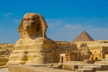 Altın Kahire güneşinin altındaki Büyük Giza Piramidi 'nin çarpıcı manzarası. Yüzyılların ötesine geçen sonsuz güzellik. Eski Mısır 'ın harikalarını keşfeden her gezgin için görülmesi gereken bir şey..