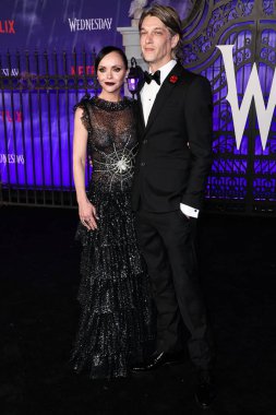 Rodarte giyimli Amerikalı aktris Christina Ricci ve koca / saç stilisti Mark Hampton, Netflix 'in Çarşamba günkü birinci sezonunun Dünya Premiere' ine 16 Kasım 2022 'de Hollywood Legion Theater' da düzenlenen Hollywood American Legion Post 43 'te geldiler. 