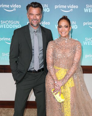 Josh Duhamel and  Jennifer Lopez (J.Lo) wearing a Valentino sheer dress and Tyler Ellis clutch arrive at the Los Angeles Premiere Of Amazon Prime Video's 'Shotgun Wedding' on January 18, 2023 in Hollywood, Los Angeles