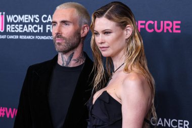 American singer and songwriter Adam Levine of American pop rock band Maroon 5 and wife/Namibian model Behati Prinsloo arrive at The Women's Cancer Research Fund's An Unforgettable Evening Benefit Gala 2023 held at the Beverly Wilshire, USA clipart