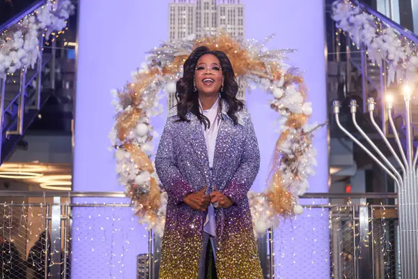 stock image American talk show host, television producer, actress, author and media proprietor Oprah Winfrey wearing a coat by Oscar de la Renta attends as Oprah Winfrey And The Cast Of Warner Bros.' 'The Color Purple' Light The Empire State Building PURPLE