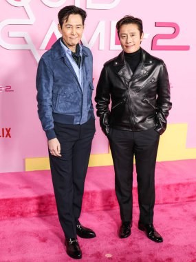 Lee Jung-jae and Lee Byung-hun arrive at the Los Angeles Premiere And Fan Event For Netflix's 'Squid Game' Season 2 held at the Los Angeles City College on December 12, 2024 in Los Angeles, California, United States.  clipart