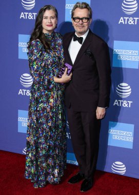 'Ben şaşkına döndüm': Sir Gary Oldman, Kral III. Charles 'ın Şövalyeliği Hakkında Açılıyor. PALM SPRINGS, CA, ABD - JANUARY 03: Gisele Schmidt ve kocası / İngiliz aktör, yönetmen ve müzisyen Gary Oldman (Sir Gary Leonard Oldman) 