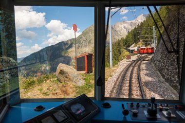 View from the window of red historic train to Mer de Glace glacier in Chamonix. France. Alpine tourist attractions. clipart