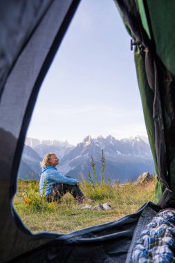 Mont Blanc tepesine bakan Alps dağlarında çadırda dinlenen genç bir kadın. Chamonix, Fransa 'da sürdürülebilir turizm.