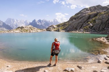 Fransız Alp Dağları 'nda Mont Blanc zirvesine bakan gölde yürüyüş yapan bir kadın. Avrupa 'da sürdürülebilir turizm