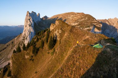 Woman camping in Appenzell Alps with a tent. Eco tourism in Switzerland. clipart