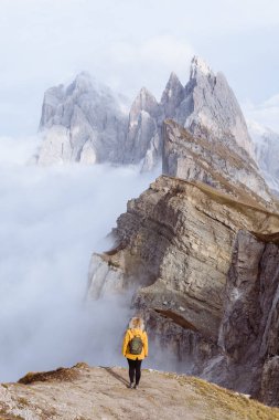 Dolomite Alpleri, İtalya 'da Seceda Dağı' nın önünde duran parlak yağmurluklu kadın. Dikey yönelim.