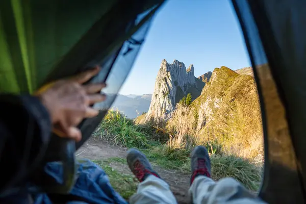 Appenzell Alpleri 'nde kamp yapan adam, çadırın içini görüyor. İsviçre 'de çevre turizmi.