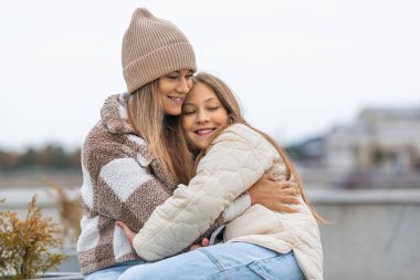 Anne ve kızı çok iyi arkadaşlar. Nesiller arasında güven ve anlayış. Anne ve kızları açık havada yürürken kucaklaşıyorlar..
