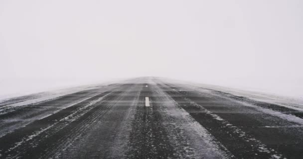 無限の氷の砂漠では 道路の背景に吹雪 極端な気象条件での旅行 4K映像 — ストック動画