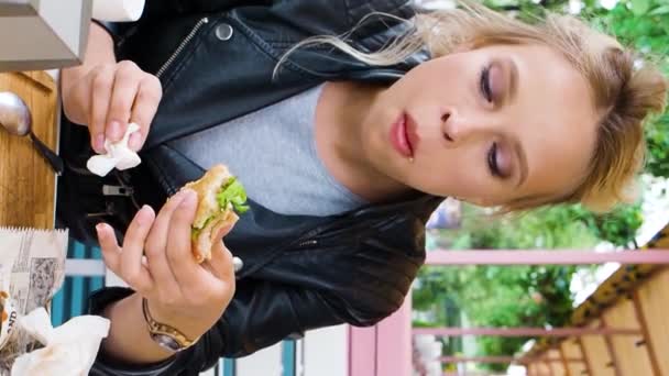 Vídeo Vertical Uma Jovem Mulher Loira Caucasiana Comendo Fast Food — Vídeo de Stock