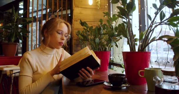 Egy Fiatal Szőke Könyvet Olvas Miközben Egy Kávézóban Lassú Mozgás — Stock videók