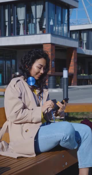 Young Asian Woman Sits Bench Communicates Online Smartphone She Flirts — Stock Video