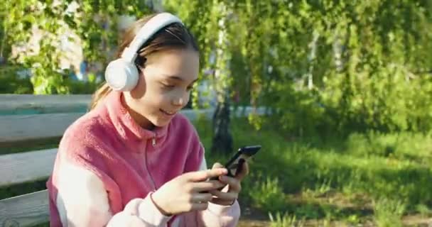 Ten Years Old Girl Smartphone Headphones She Chatting Friends Outdoor — 비디오