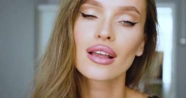 Güzel sarışın bir kadın burnunu komik bir şekilde buruşturur ve başını sallar. Hayır diyor. 4k 'lık yakın çekim..