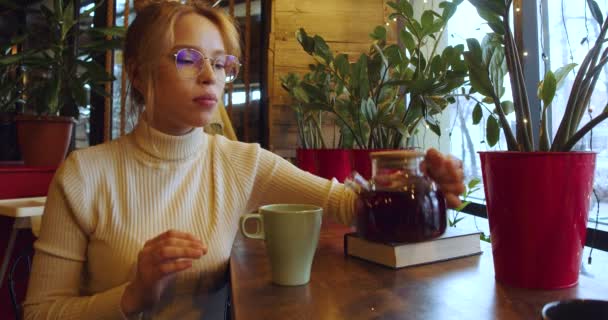 Video Young Woman Glasses Pouring Fragrant Fruit Tea Mug Slow — Stockvideo