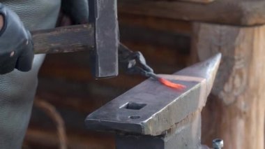 Demirci ve Anvil, bir demircinin el ve çekiç yakın çekimi ve küçük bir metal parçasının dövülmesi. 4k görüntü.