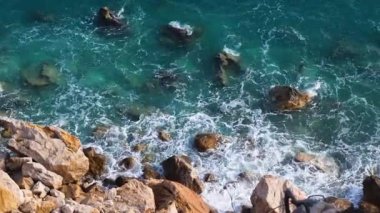 Aerial FHD footage of seashore in sunny day. Beautiful sea surface nature view. Top down bird eye view. Slow motion video.