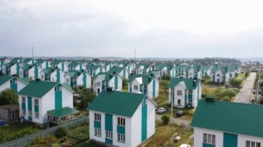 An aerial view of several dozen identical houses - the residence of a community or commune. A society of equality for all. 4k footage.