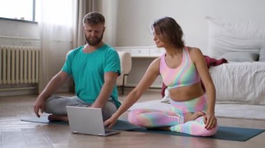 FHD görüntüleri - orta yaşlı bir çift evde meditasyon yaparken online yoga dersleri alıyorlar..
