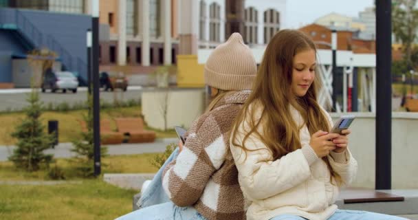 Modern Addictions Footage Two Teenage Girls Sitting Buried Smartphones While — Stockvideo