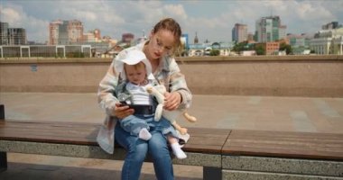 Young mother with her daughter watching educational videos for children through an online application for a smartphone. 4k footage.