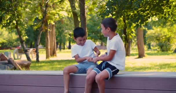 タブレット屋外のために戦う2人の男の子 子供とガジェット中毒の概念 4K映像 — ストック動画