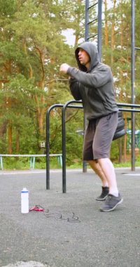 Middle aged man during outdoor workout. Shadow boxing exersice. Full length vertical 4k footage. Concept of keeping fit in your 40s.