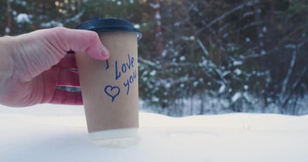 Αρσενικά Και Θηλυκά Χέρια Βάζουν Ποτήρια Καφέ Στο Χιόνι Επιγραφές — Αρχείο Βίντεο