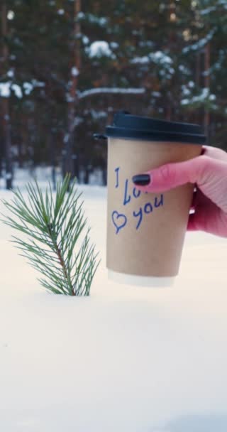 女人手在雪地里放了一杯咖啡 上面写着我爱你 慢动作垂直4K镜头 — 图库视频影像