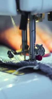 Vertical video of a female hands working on a sewing machine. Close-up 4k footage.