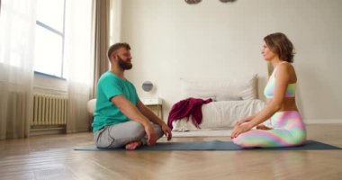4K görüntüler. Orta yaşlı bir çift birbirlerinin önünde meditasyon yapıyorlar. Yoga, pilates ve sağlık hizmeti konsepti.