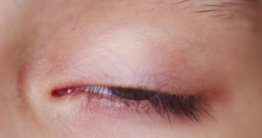 Close-up 4k footage of eye of Kid. Bright beauty female open eyes with pupil dilation.
