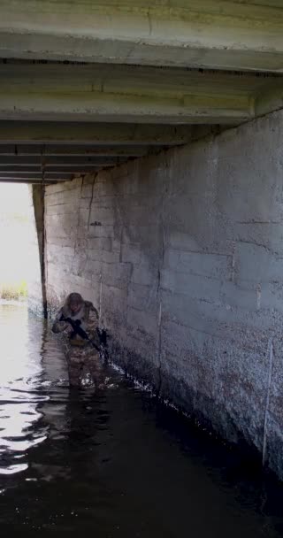 一名雇佣兵士兵沿着水淹的隧道偷偷地潜入敌人的地堡 地下建筑中现代军事行动的概念 4K镜头 — 图库视频影像