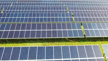 Aerial view of a solar panels stand in a row in the fields green energy landscape electrical power ecology innovation nature environment. Slow motion. 4k footage.