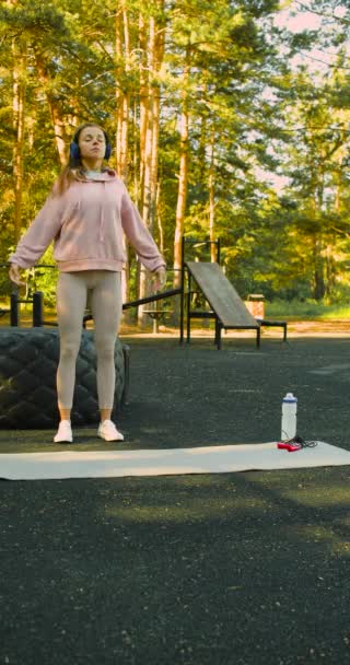 Young Woman Headphones Meditates Calm Music While Standing Sports Ground — Stockvideo