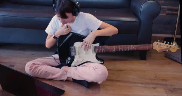 Teenager Girl Guitar Headphones Sitting Floor Front Laptop She Listening — 图库视频影像