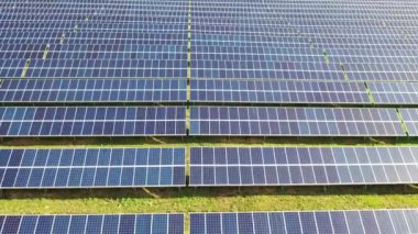 Aerial view of a solar panels stand in a row in the fields green energy landscape electrical power ecology innovation nature environment. Slow motion. 4k footage.