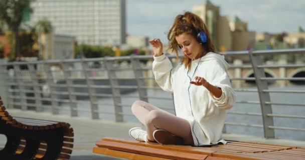 Young Woman Puts Her Smartphone Takes Her Headphones Begins Meditate — Stock video