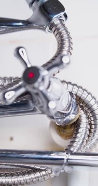 Leaky faucet. Along with the water, your money also flows away. Close-up vertical 60 fps 4k footage.