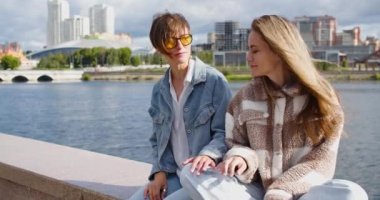 Two lesbians enjoy each other during outdoor walking. The concept of love and relationships. One woman rests her head on the shoulder of another. A beautiful romantic moment between two lovers.