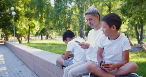 Asian Family Mother Two Sons Sit Buried Smartphones Outdoor Smartphone — ストック動画