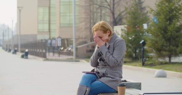 40歳の女性がメッセージを受け取り激しく動揺する 頭を下げて腕を包み込む 悲しみと失望 — ストック動画